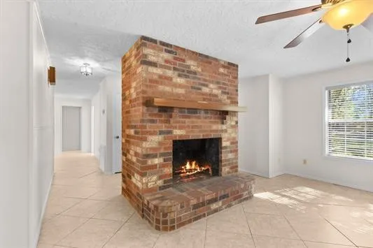 a view of an empty room with a fireplace and a window