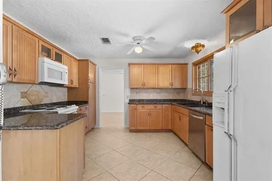 a kitchen with stainless steel appliances granite countertop a stove sink and cabinets