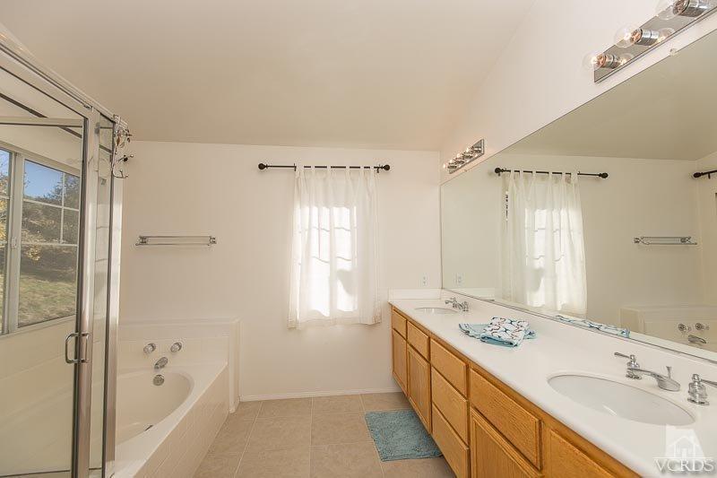 524 Shadow Lane Simi Valley, CA 93065 - Photo 18 of 40 a bathroom with a granite countertop sink a mirror a bathtub and shower