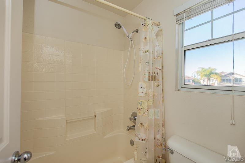 524 Shadow Lane Simi Valley, CA 93065 - Photo 23 of 40 a bathroom with a shower curtain a window and a shower