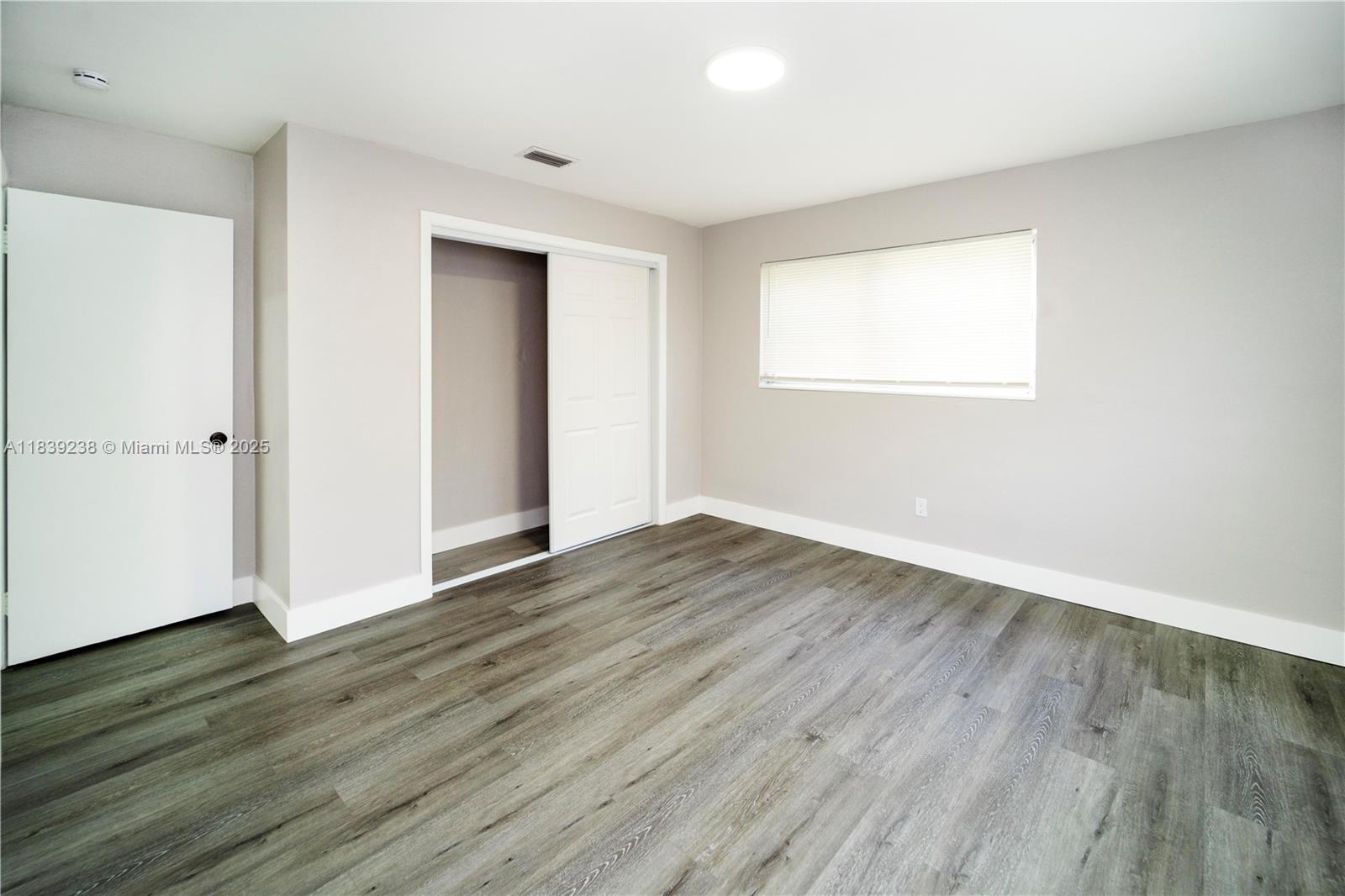 6990 Southwest 28th Street Miramar, FL 33023 - Photo 14 of 33 an empty room with wooden floor and windows