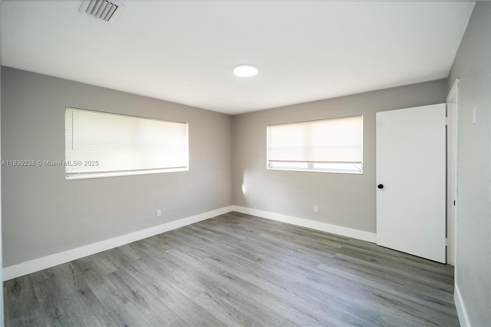 6990 Southwest 28th Street Miramar, FL 33023 - Photo 16 of 33 an empty room with wooden floor and windows