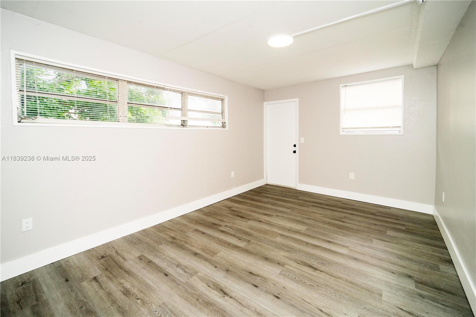 6990 Southwest 28th Street Miramar, FL 33023 - Photo 19 of 33 a view of an empty room with wooden floor and a window