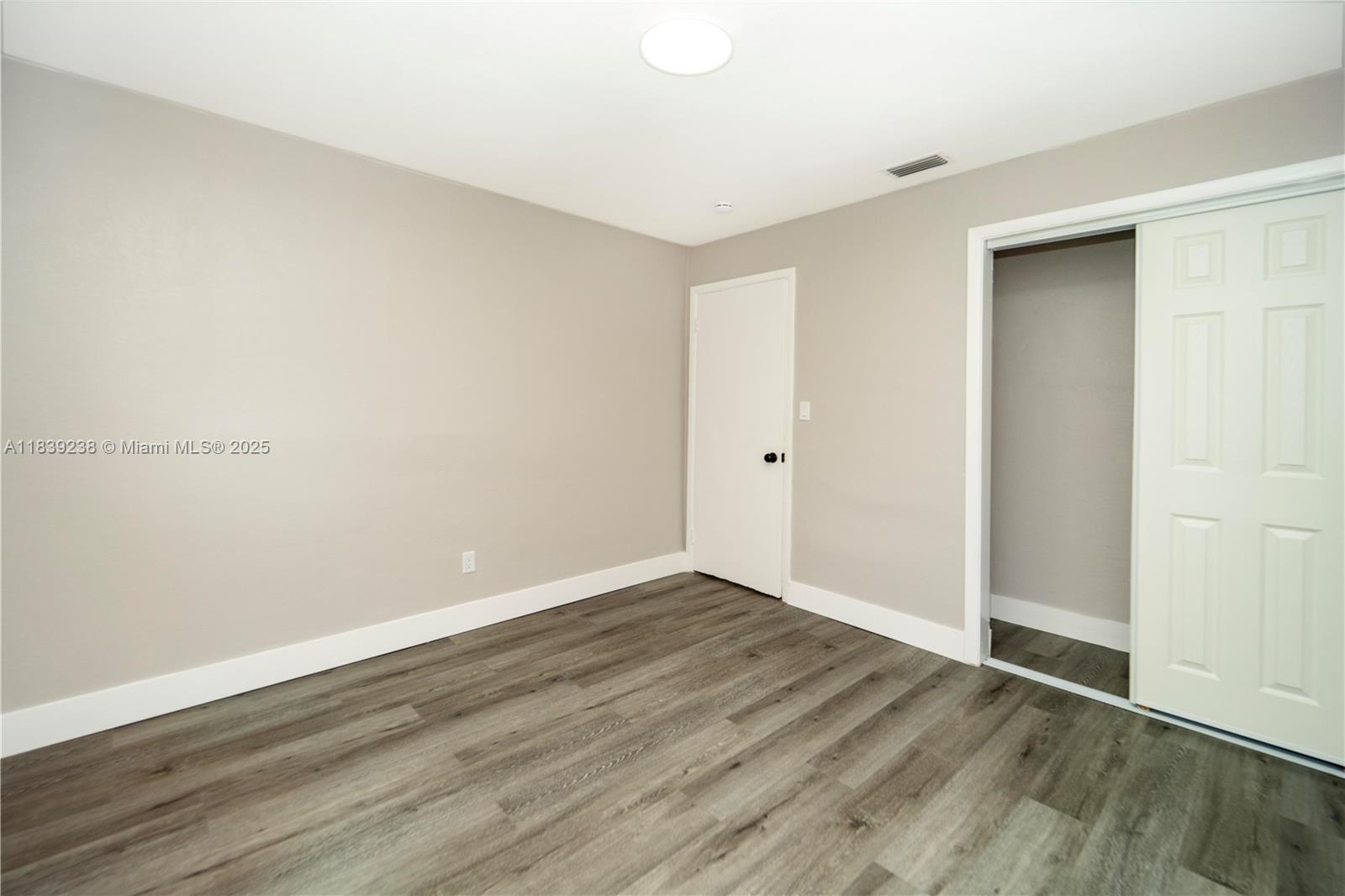 6990 Southwest 28th Street Miramar, FL 33023 - Photo 20 of 33 a view of an empty room with wooden floor