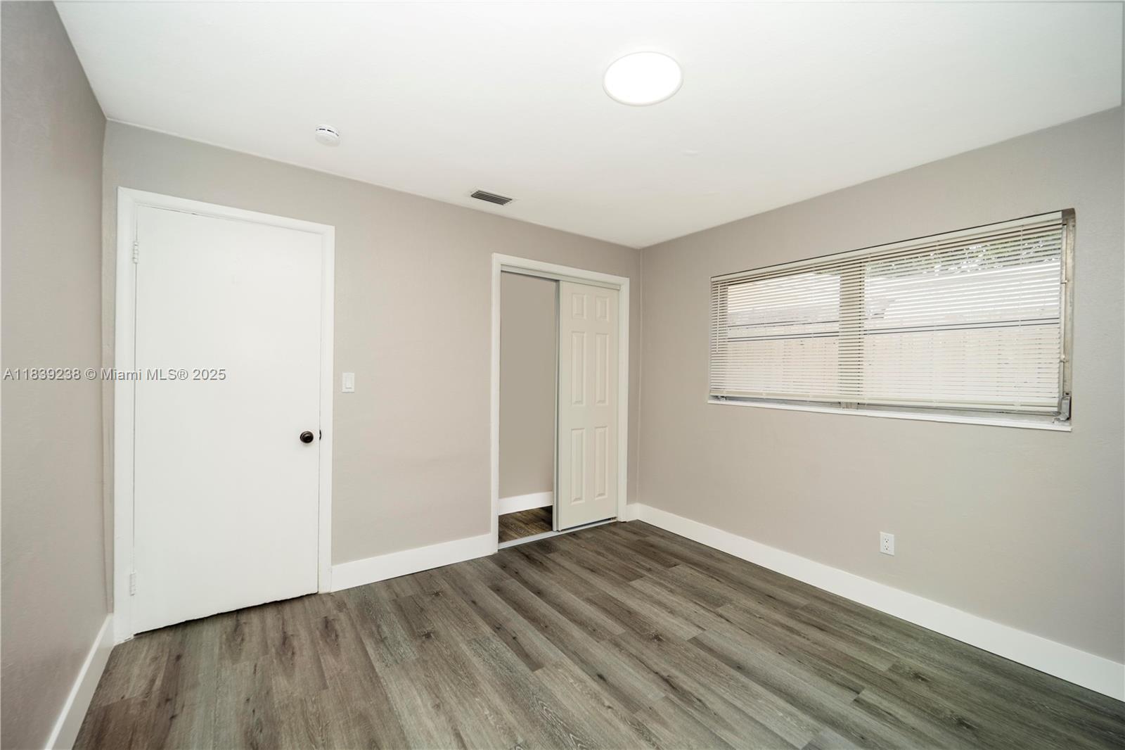 6990 Southwest 28th Street Miramar, FL 33023 - Photo 23 of 33 an empty room with wooden floor and windows