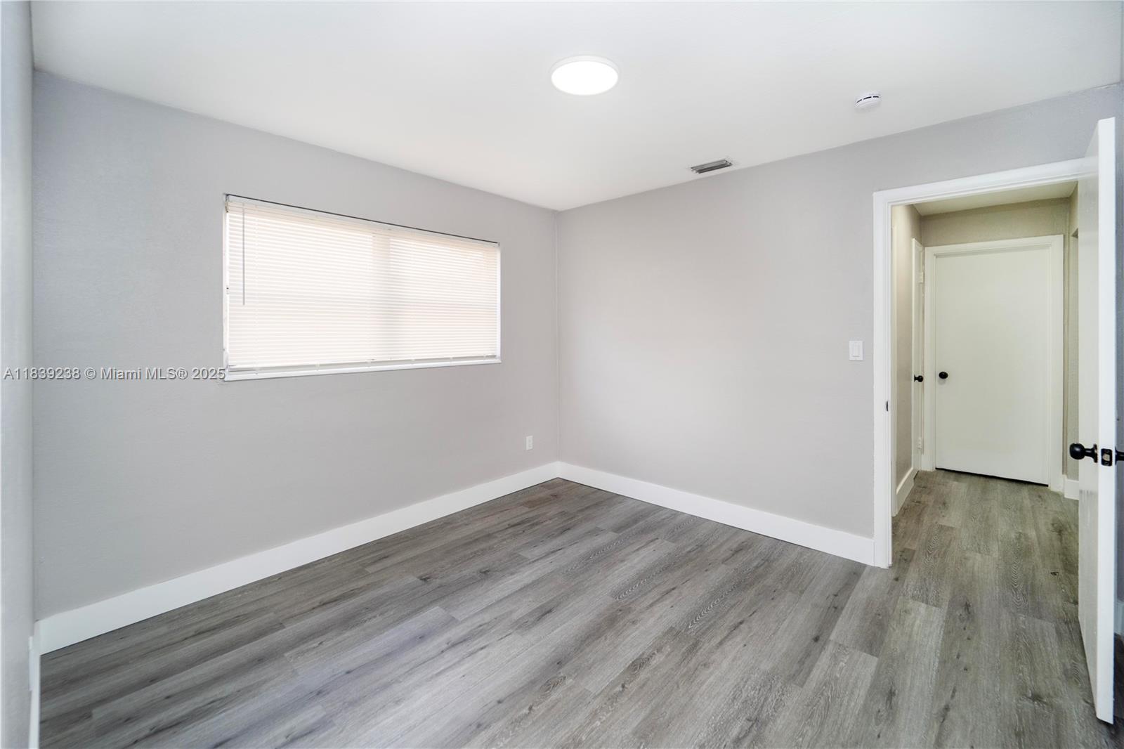 6990 Southwest 28th Street Miramar, FL 33023 - Photo 24 of 33 an empty room with wooden floor and windows