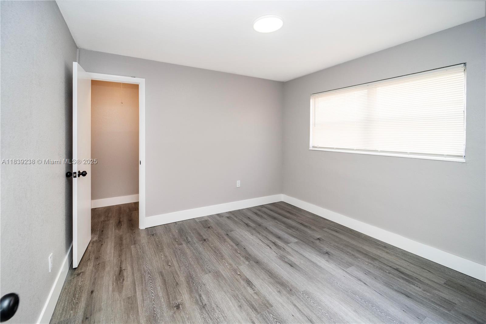 6990 Southwest 28th Street Miramar, FL 33023 - Photo 26 of 33 an empty room with wooden floor and a window