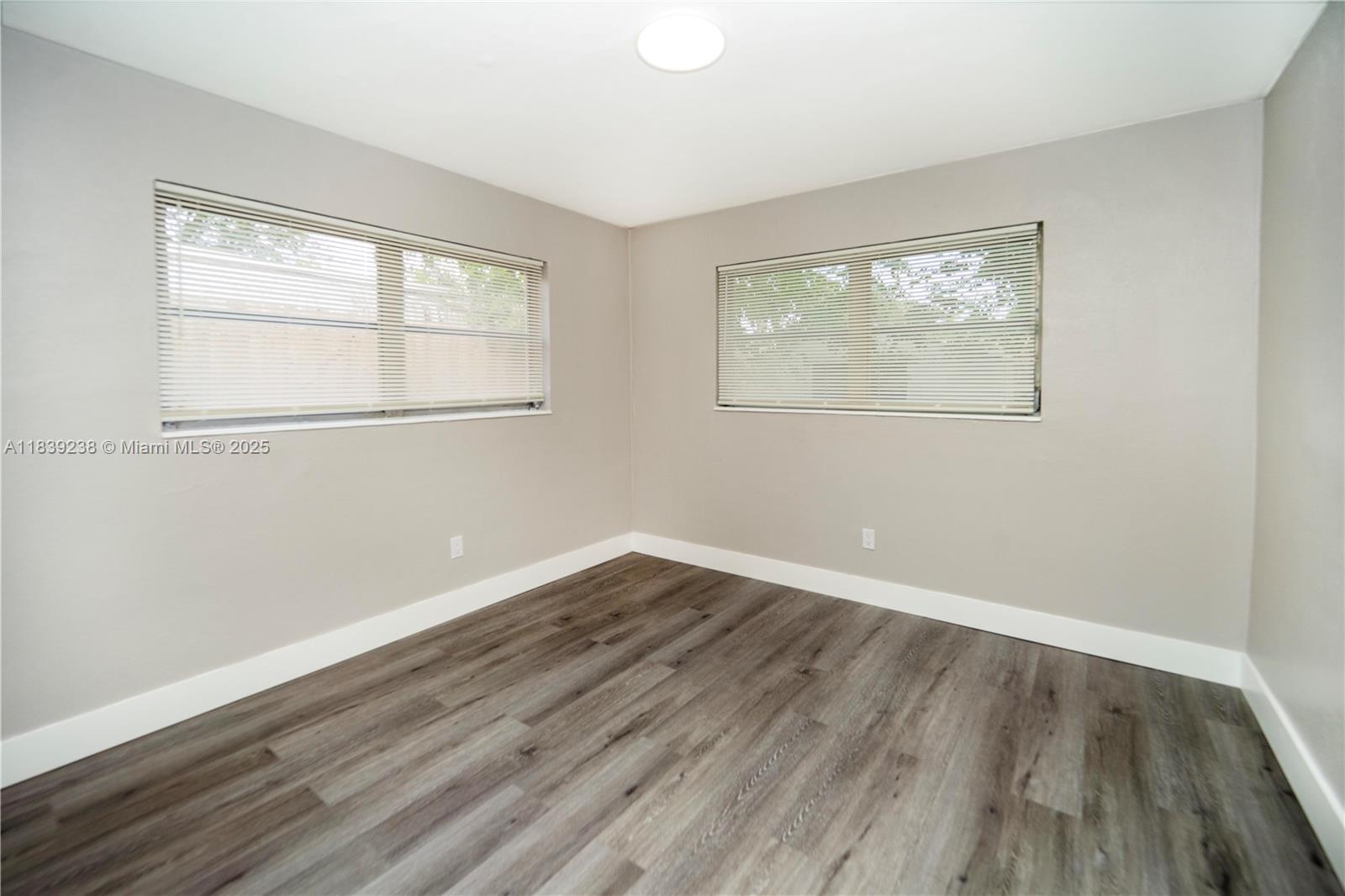 6990 Southwest 28th Street Miramar, FL 33023 - Photo 27 of 33 an empty room with wooden floor and windows