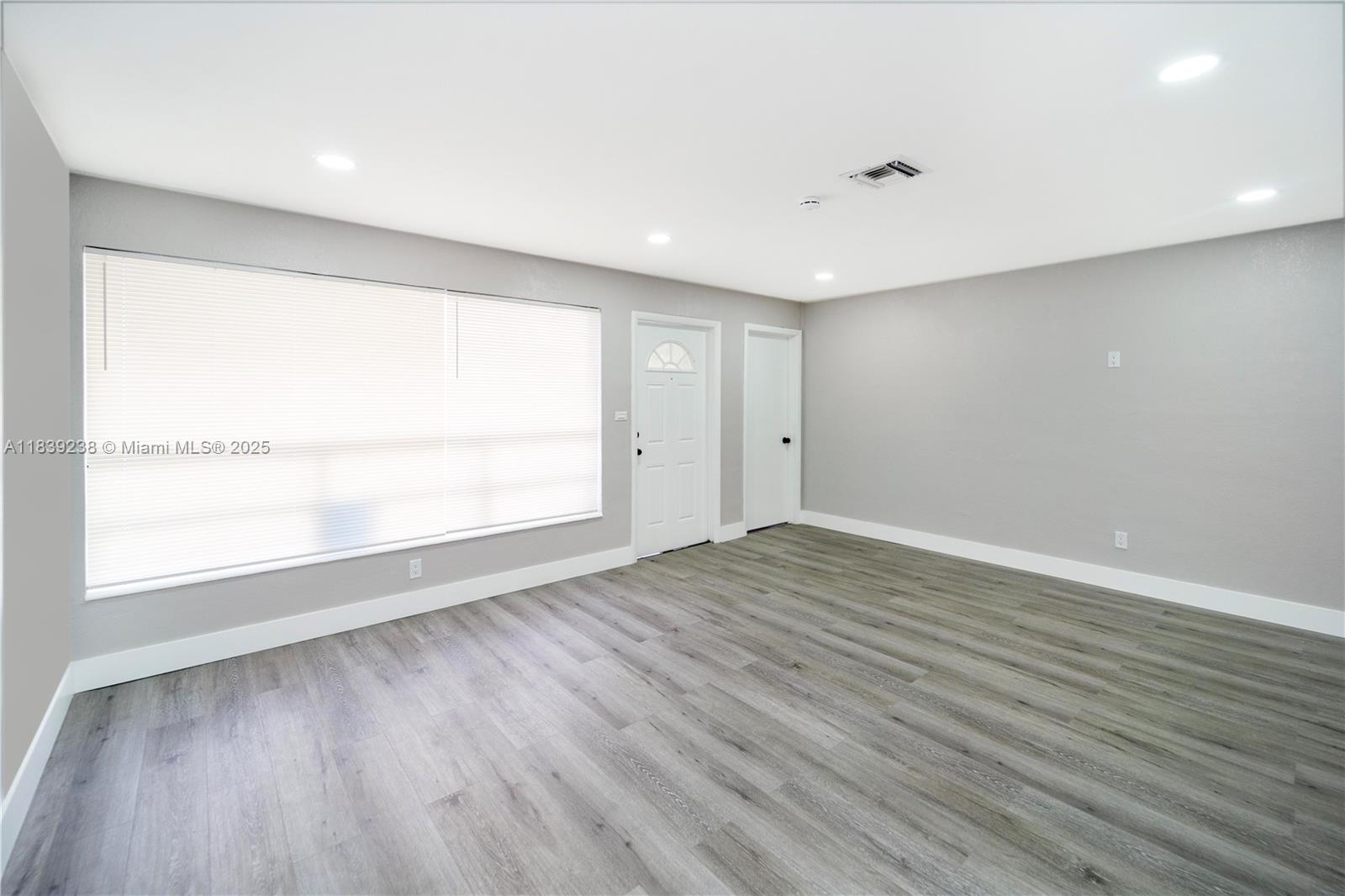 6990 Southwest 28th Street Miramar, FL 33023 - Photo 29 of 33 an empty room with wooden floor and windows