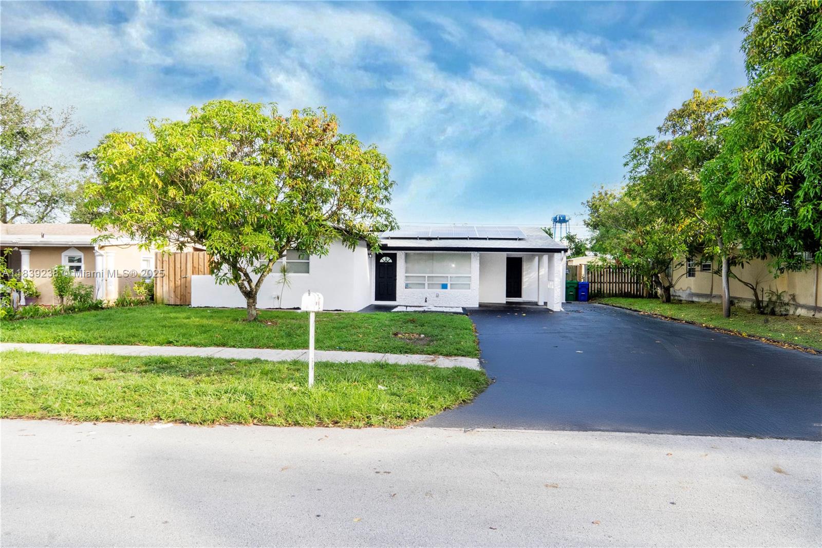 6990 Southwest 28th Street Miramar, FL 33023 - Photo 4 of 33 a front view of a house with a garden and trees