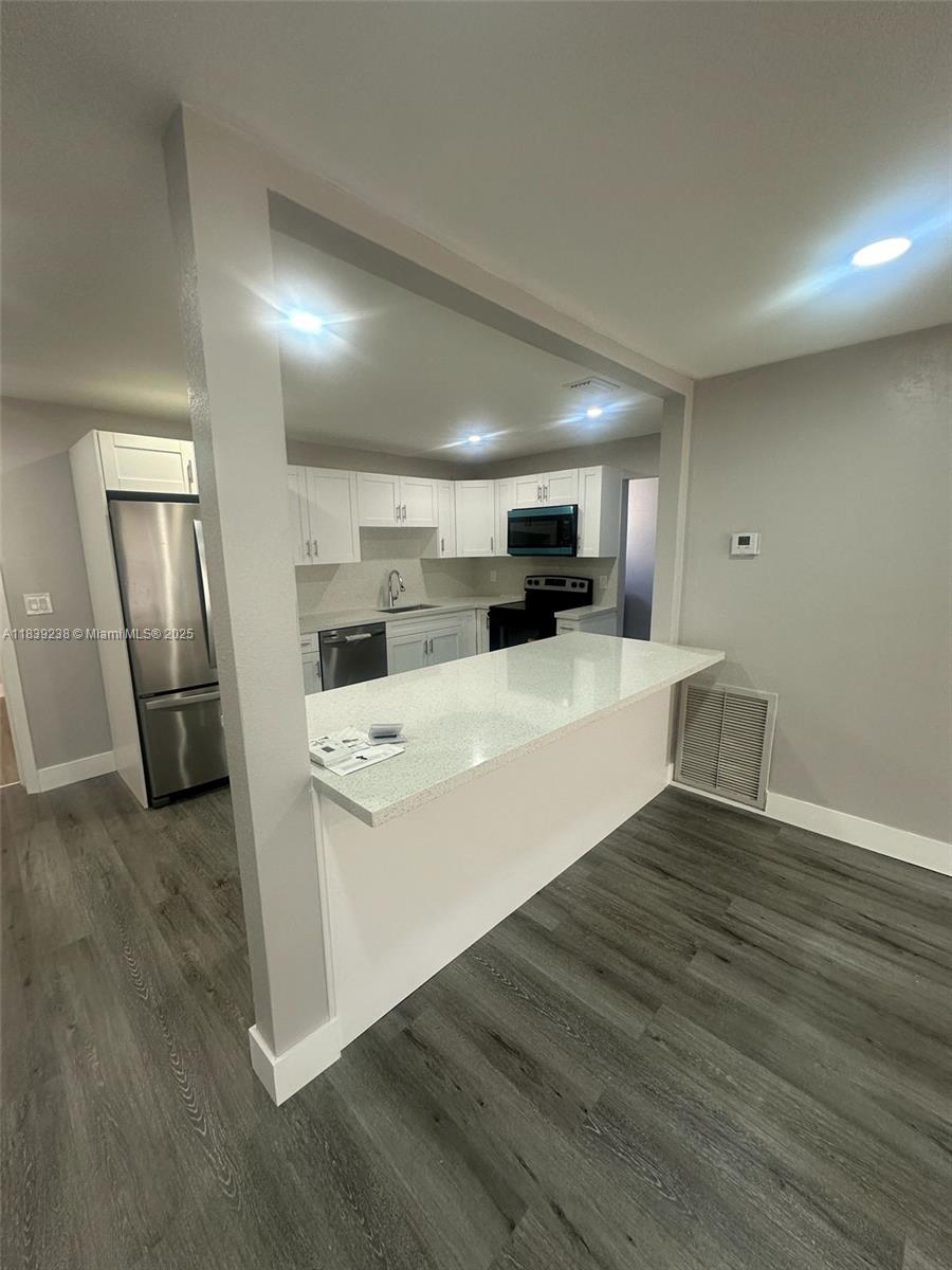 6990 Southwest 28th Street Miramar, FL 33023 - Photo 8 of 33 a large white kitchen with wooden floor