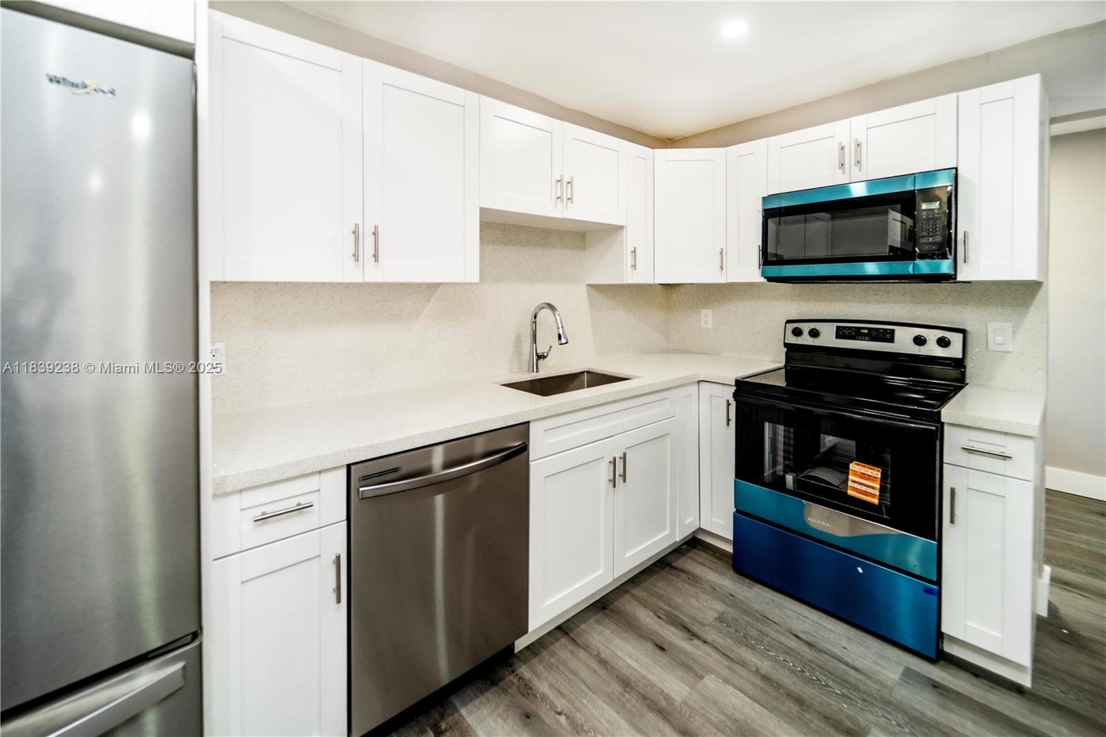 6990 Southwest 28th Street Miramar, FL 33023 - Photo 9 of 33 a kitchen with white cabinets and stainless steel appliances