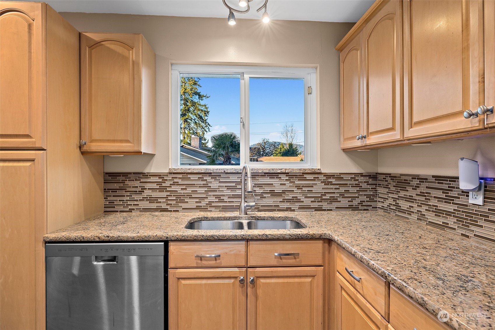 14610 Southeast 113th Street Renton, WA 98059 - Photo 12 of 34 a kitchen with granite countertop a sink and white cabinets