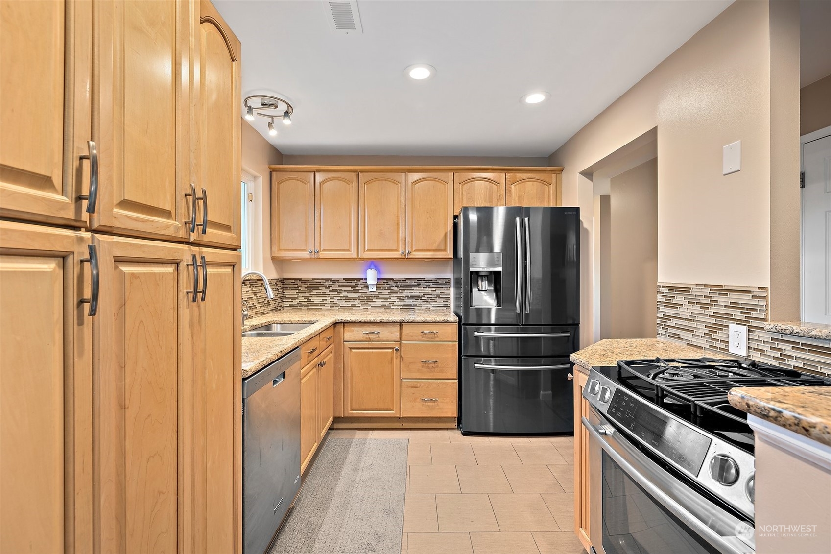 14610 Southeast 113th Street Renton, WA 98059 - Photo 9 of 34 a kitchen with granite countertop stainless steel appliances and wooden cabinets