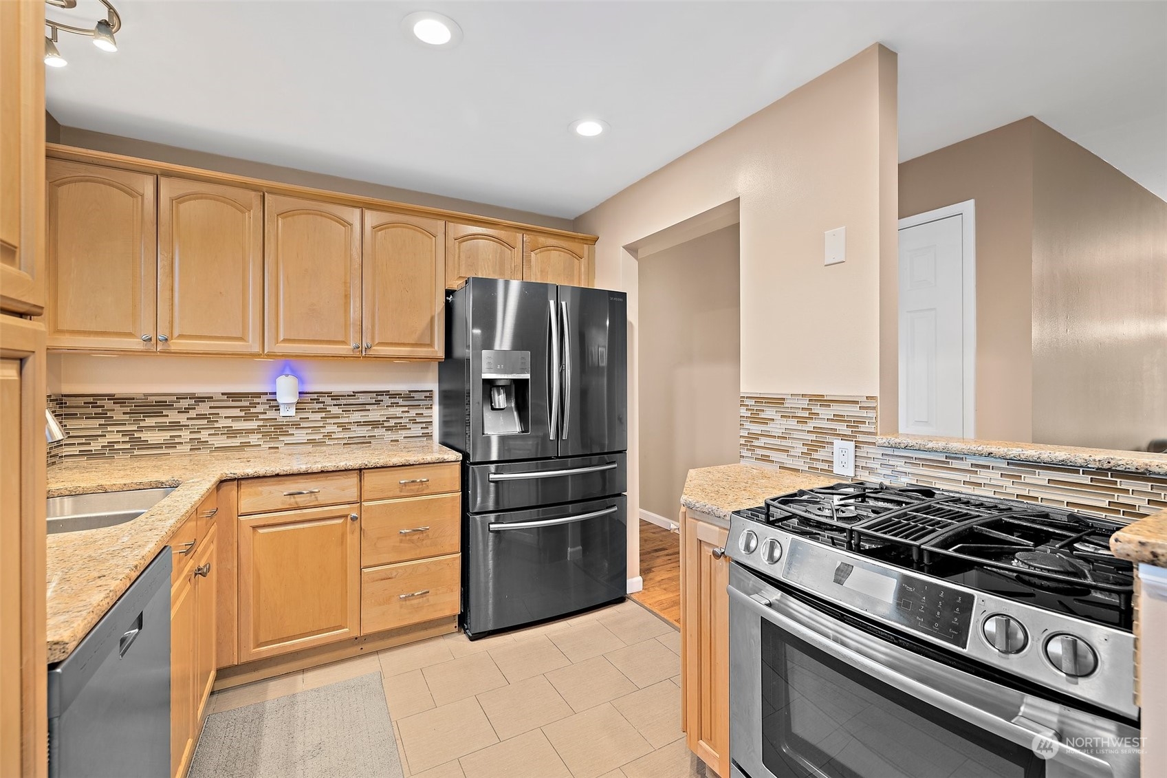 14610 Southeast 113th Street Renton, WA 98059 - Photo 10 of 34 a kitchen with granite countertop a stove and a refrigerator