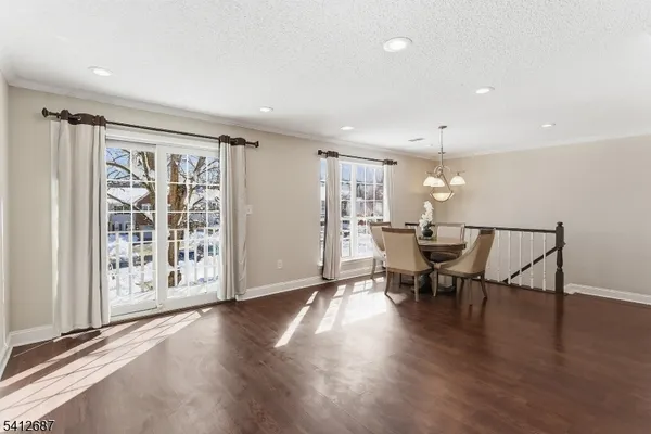 a view of a a dining room with furniture window and wooden floor