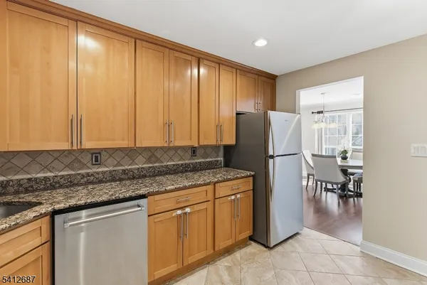 a kitchen with stainless steel appliances granite countertop a refrigerator and a stove top oven