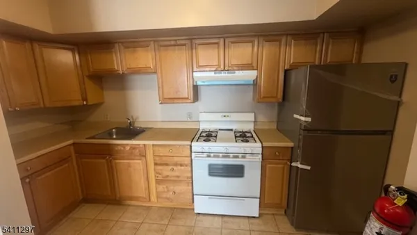 a kitchen with a stove top oven and refrigerator