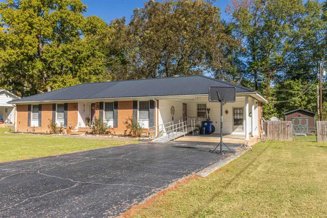 a front view of a house with a garden and patio