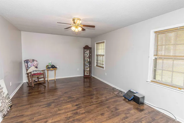 a view of a room with wooden floor lounge chair and windows