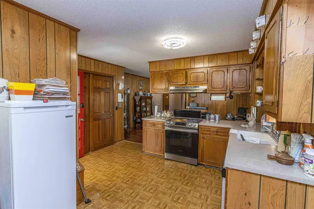 a kitchen with stainless steel appliances granite countertop a sink stove and refrigerator