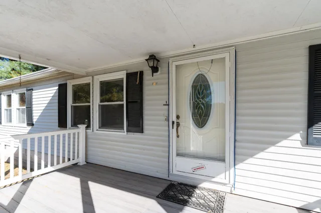 a front view of a house with swimming pool and trees
