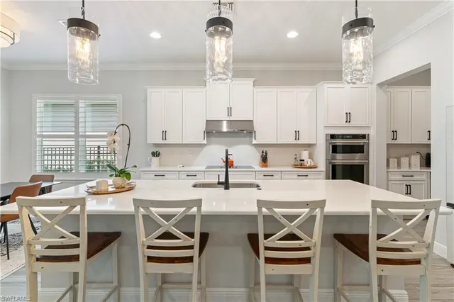 a kitchen with stainless steel appliances kitchen island granite countertop a table and chairs in it