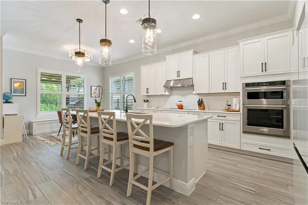 a kitchen with a dining table chairs stainless steel appliances and cabinets