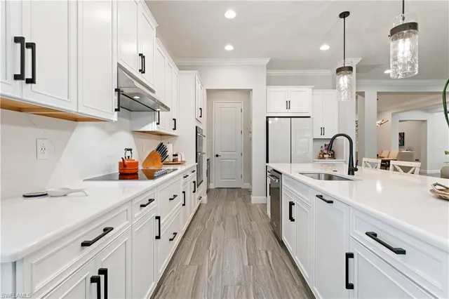 a kitchen with stainless steel appliances a sink stove and cabinets