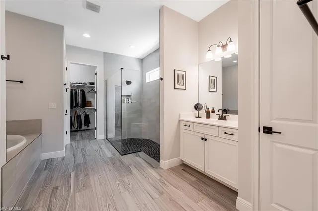 a spacious bathroom with a granite countertop sink a large mirror a toilet and shower