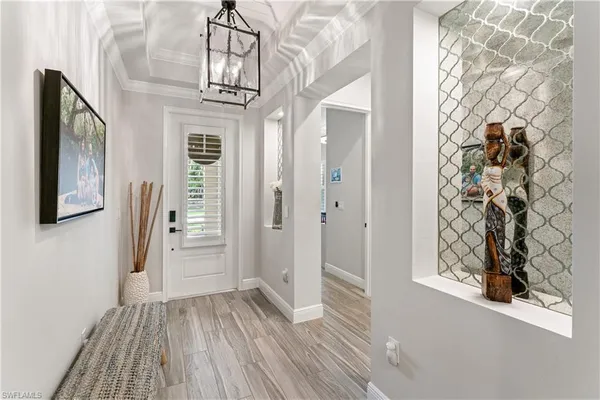 a view of a hallway with wooden floor and front door