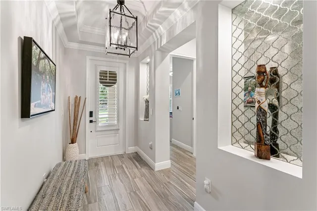 a view of a hallway with wooden floor and front door