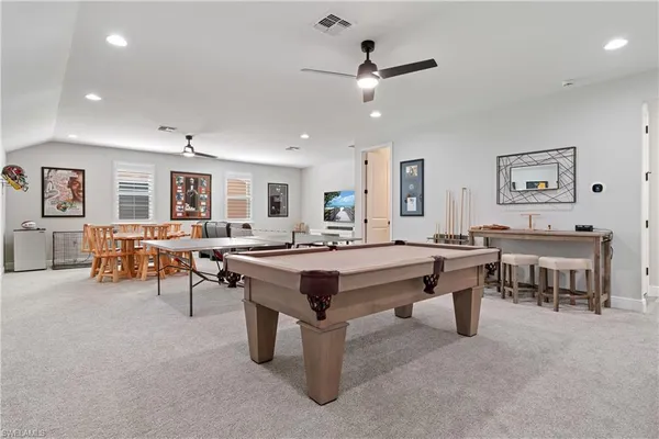 a living room with chairs a desk and a potted plant