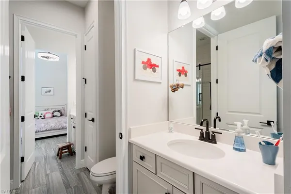 a bathroom with a sink a toilet and a large mirror