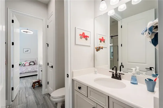 a bathroom with a sink a toilet and a large mirror