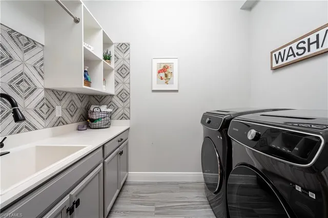 a utility room with sink dryer and washer