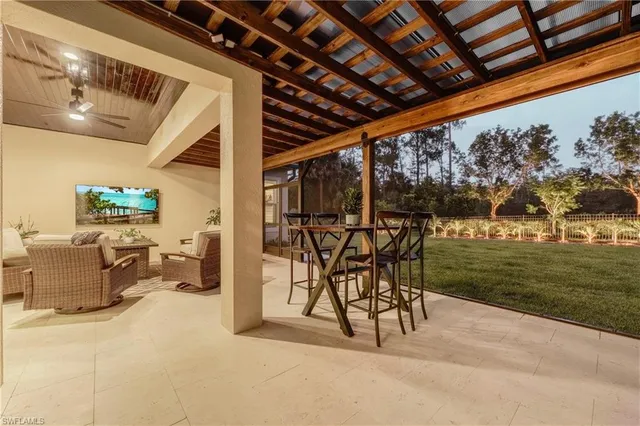 a view of a patio with a table and chairs and potted plants