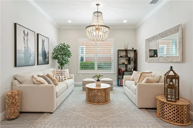 a living room with furniture a window and a chandelier