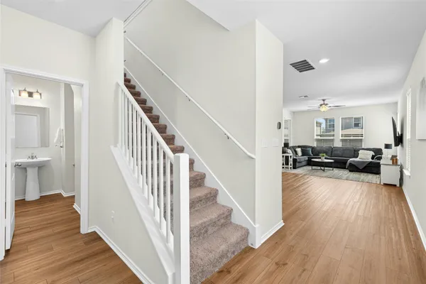 a view of a hallway with wooden floor and staircase