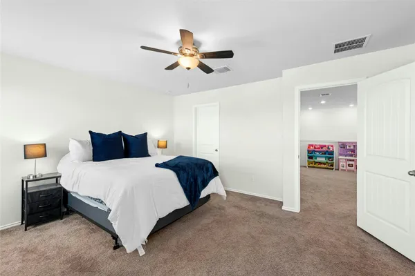 a spacious bedroom with a bed and a flat screen tv