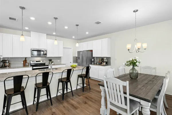 a kitchen with a counter space a sink and living room view