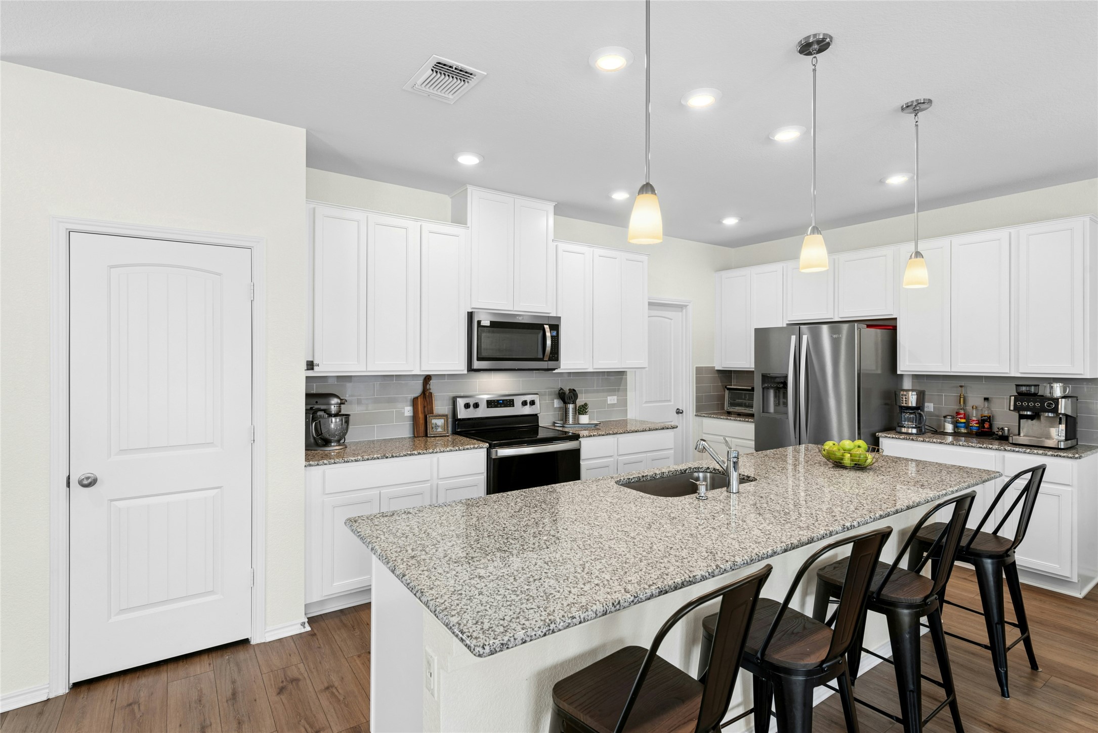 1124 Aronia Lane Georgetown, TX 78626 - Photo 6 of 31 a kitchen with a table chairs refrigerator and microwave