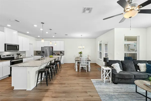 a kitchen with a table chairs refrigerator and microwave