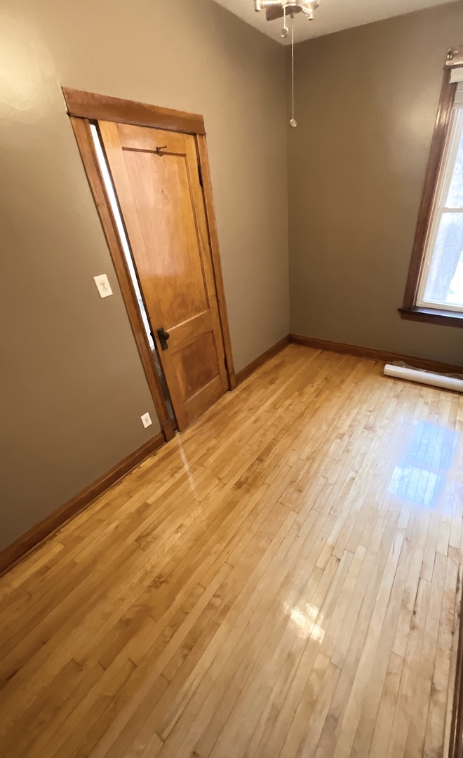 919 North Leavitt Street, Unit 2F Chicago, IL 60622 - Photo 11 of 18 an empty room with wooden floor and windows