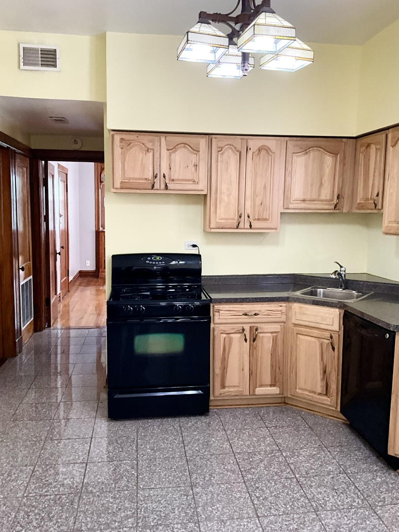 919 North Leavitt Street, Unit 2F Chicago, IL 60622 - Photo 4 of 18 a kitchen with a stove top oven cabinets and a refrigerator