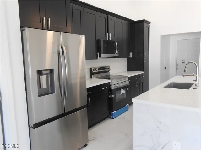 a kitchen with a refrigerator sink and stove