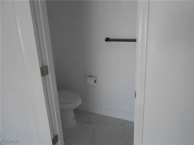 a white toilet sitting next to a shower