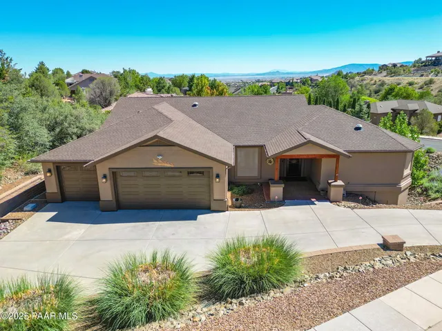 an aerial view of house with yard and trees in the background
