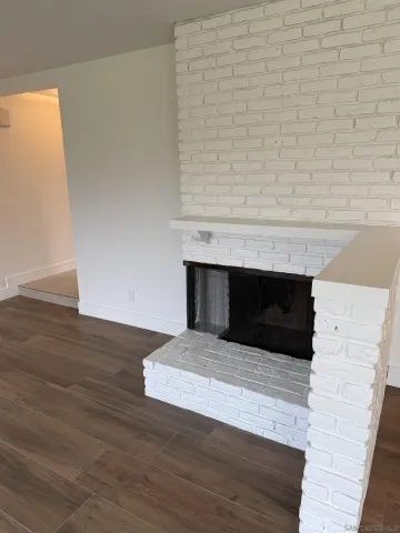 a living room with a fireplace and wooden floor