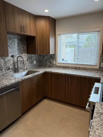 a kitchen with a sink a window and cabinets